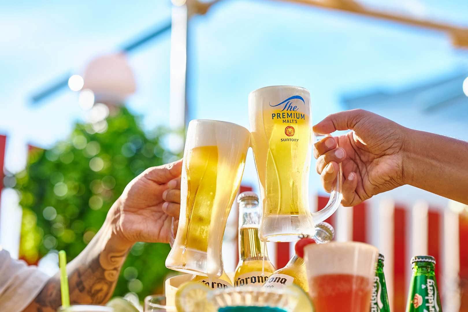 よく冷えた生ビールのジョッキで乾杯する手元