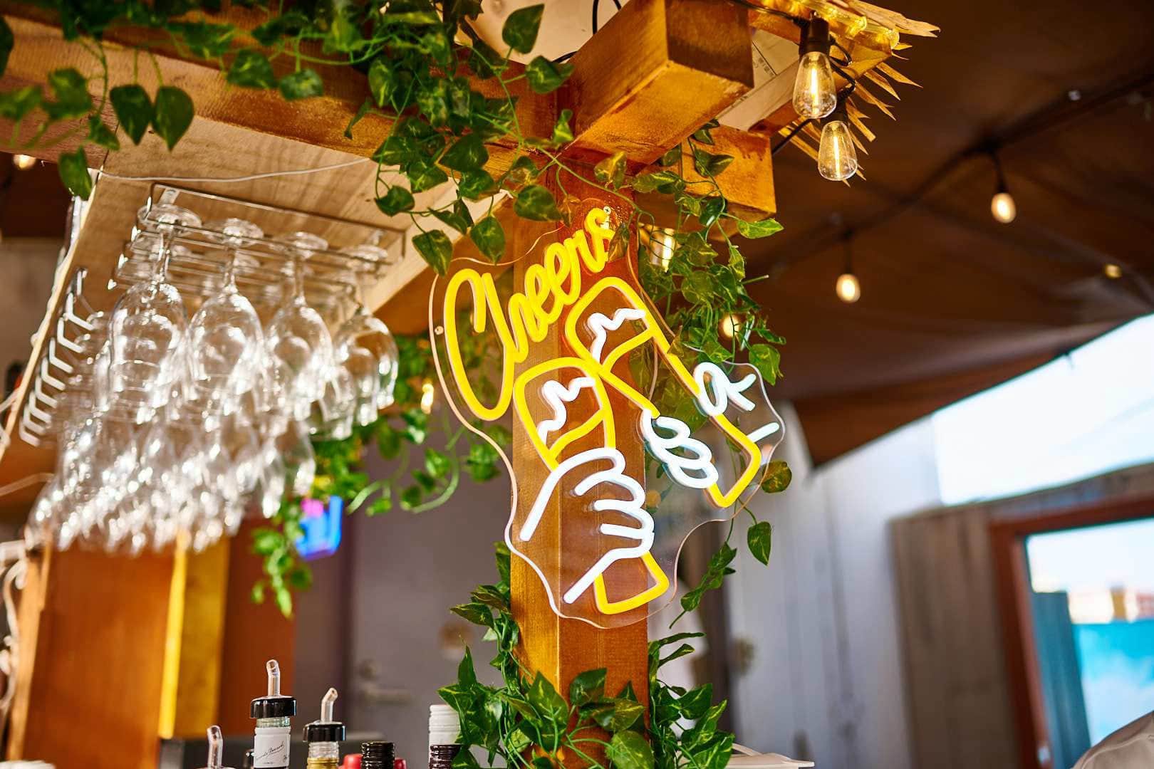 グリーンに囲まれた「Cheers」のネオンサイン